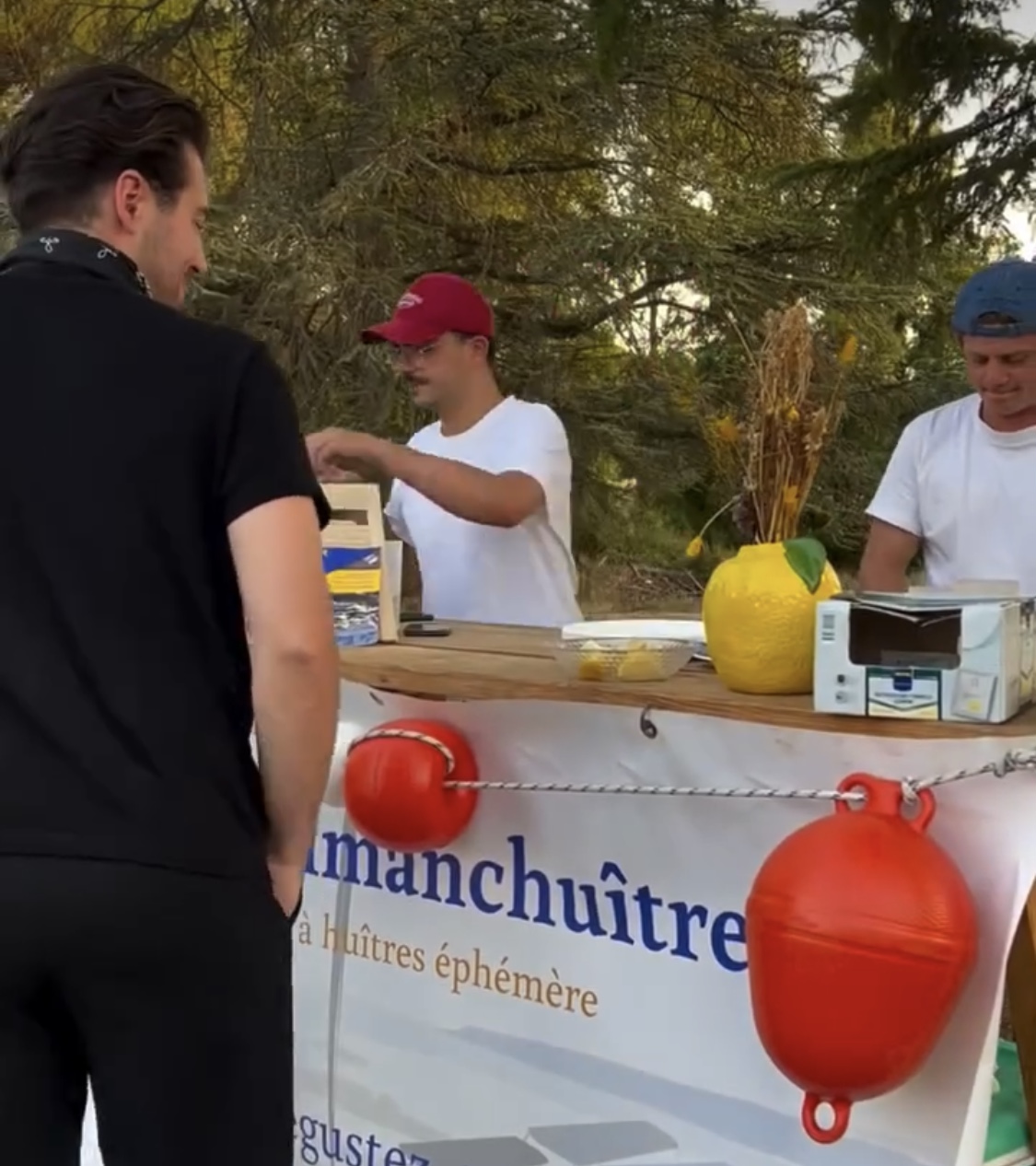 Écaillers Dimanchuitres derrière leur stand avec bouée rouge