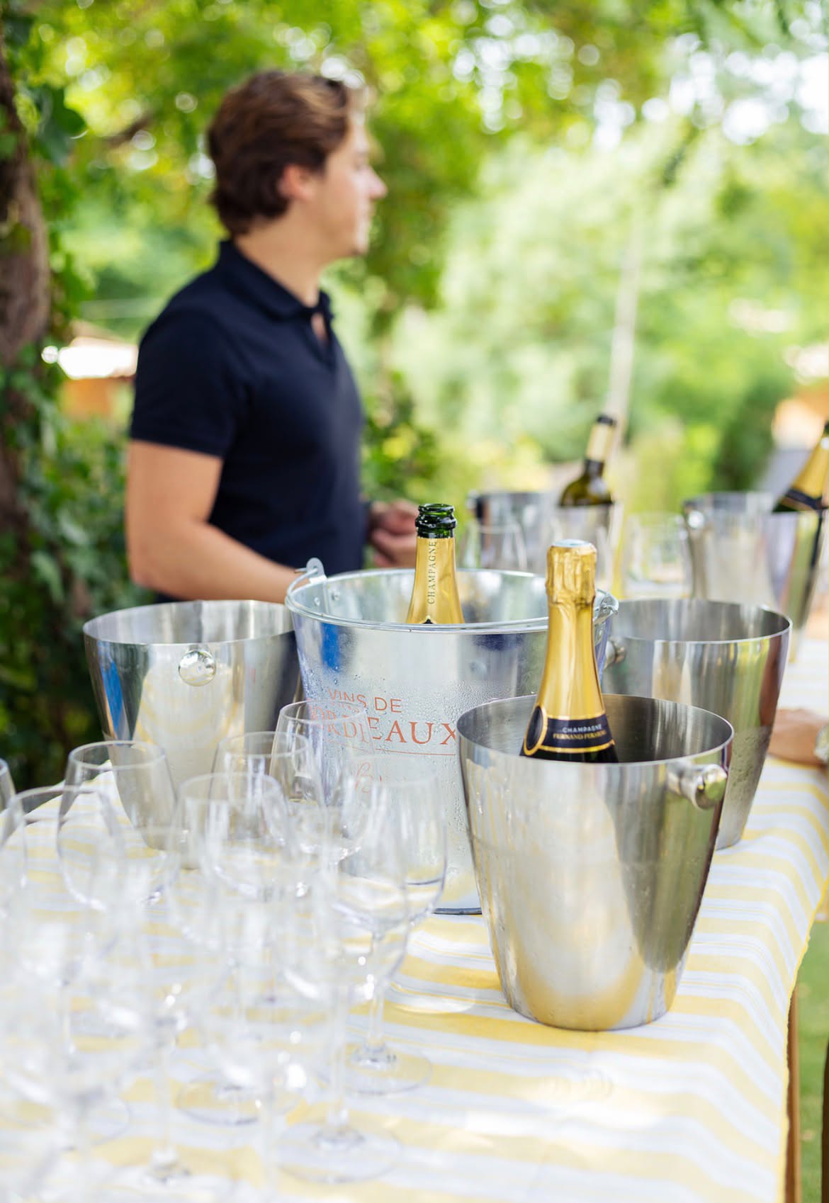 Écailler Dimanchuitres derrière son bar à huîtres, seau à champagne et coupes prêtes pour le cocktail