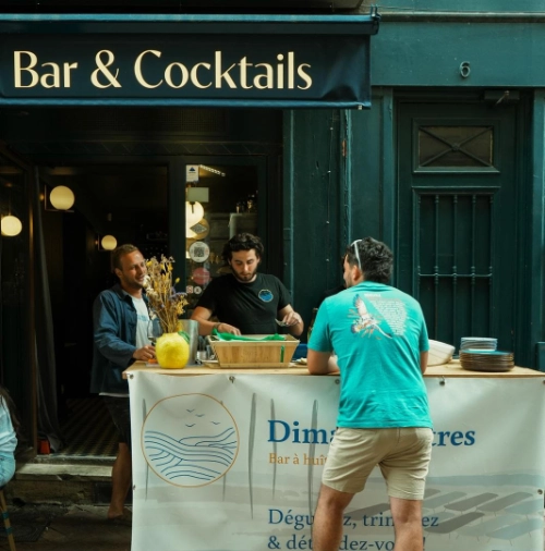 Stand Dimanchuitres installé devant un bar à cocktails de Bordeaux un dimanche