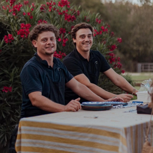 Deux écaillers souriants de Dimanc'Huîtres derrière leur stand de bar à huîtres éphémère lors d'un vin d'honneur de mariage en Gironde.